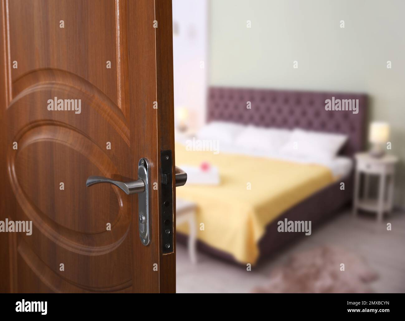 Wooden door open into modern hotel room, closeup Stock Photo