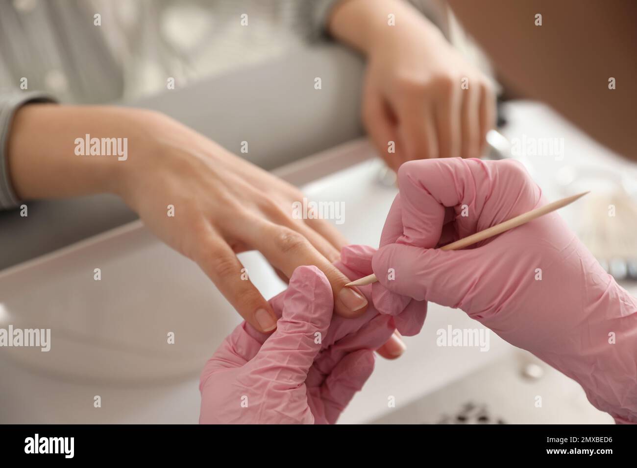 Professional manicurist working with client in beauty salon, closeup ...
