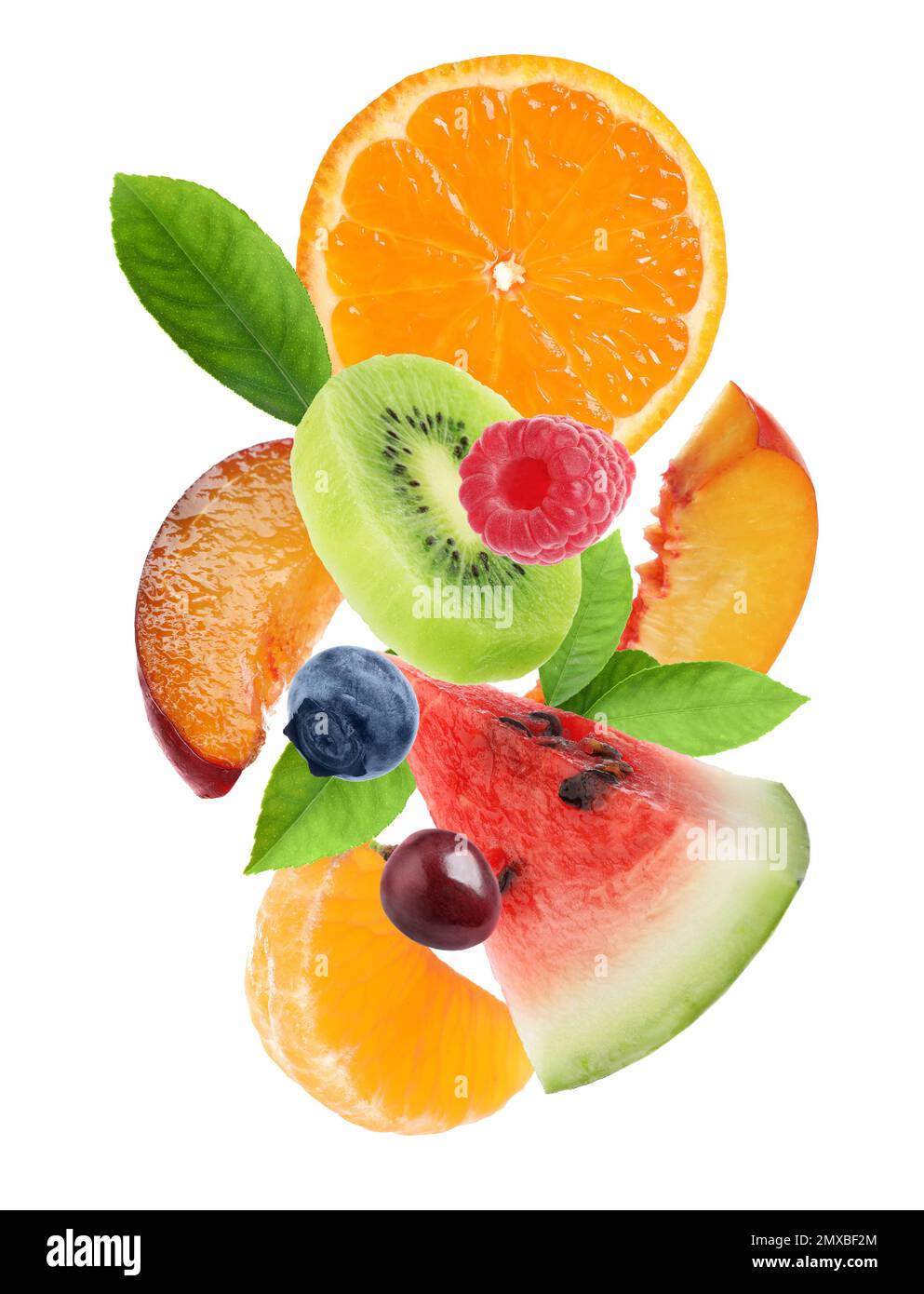 Set of different cut fresh fruits and berries falling on white