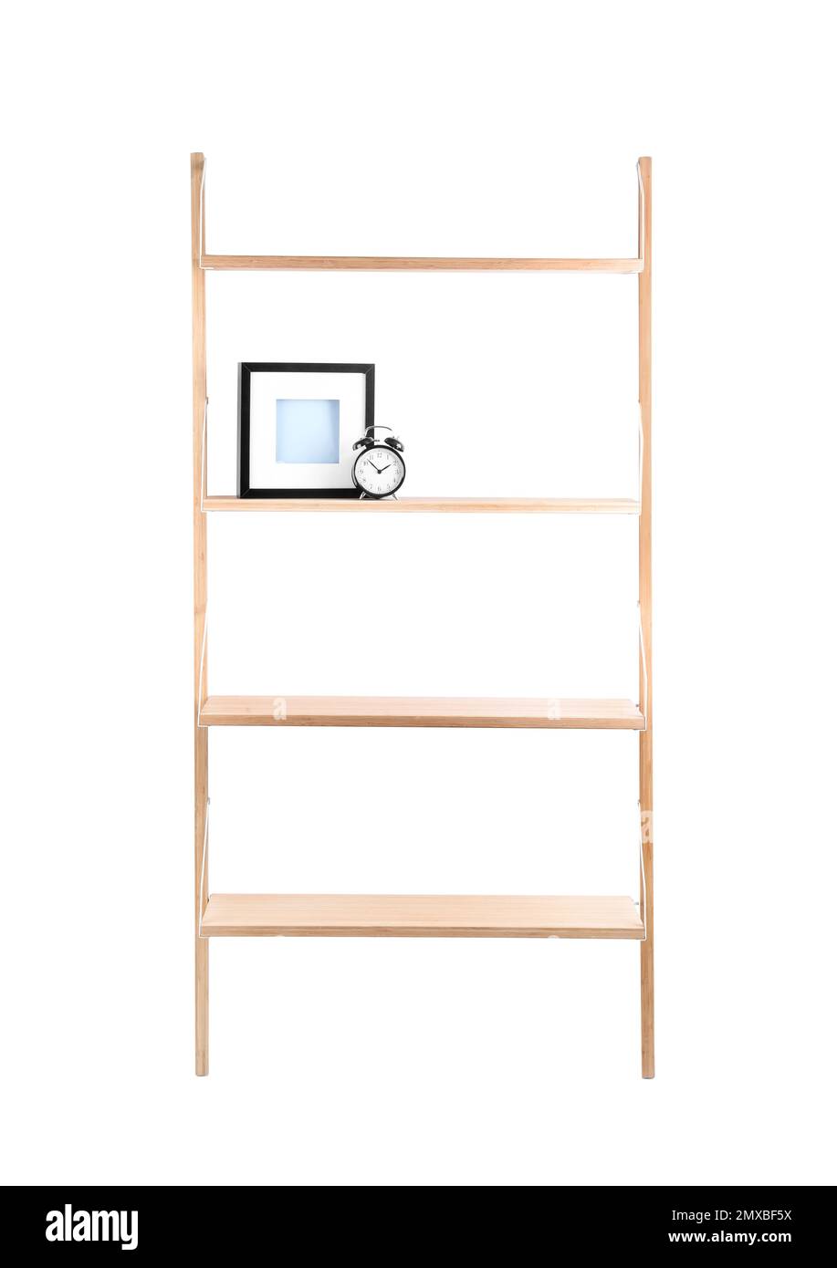 Wooden shelving unit with photo frame and alarm clock isolated on white