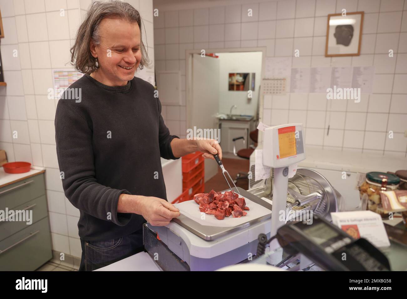 Berlin, Germany. 27th Jan, 2023. Lutz Albrecht from the Wild & Geflügel Albrecht butcher store weighs out a pound of venison goulash in his store. The prices for venison and wild boar have recently risen sharply, but venison is in demand. (to dpa 'Saddle of venison and leg of wild boar: coveted, but rare') Credit: Joerg Carstensen/dpa/Alamy Live News Stock Photo