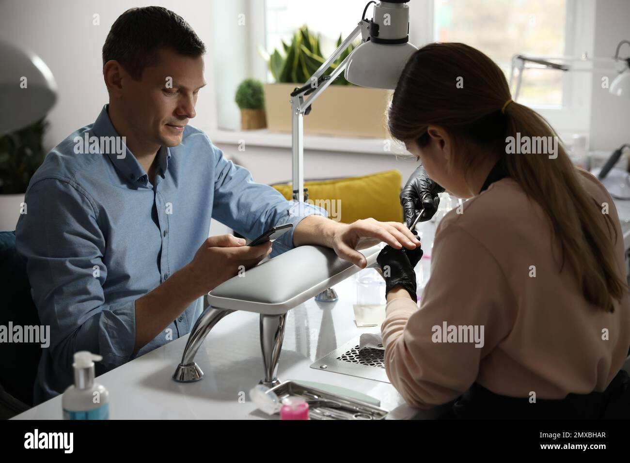 Professional manicurist working with client in beauty salon Stock Photo ...