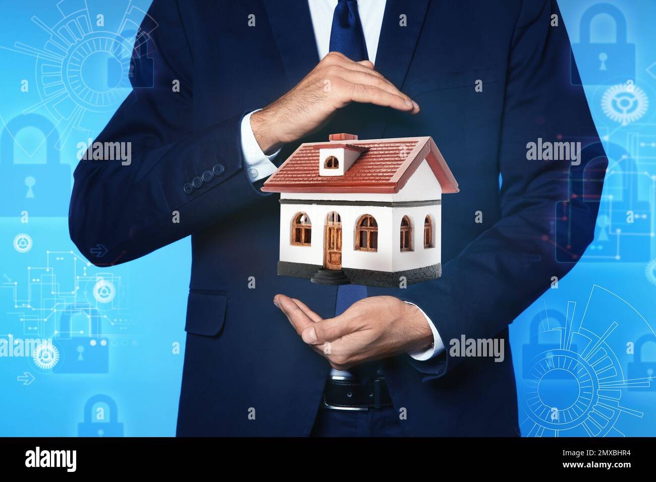 Home security concept. Man holding house on light blue background, closeup Stock Photo