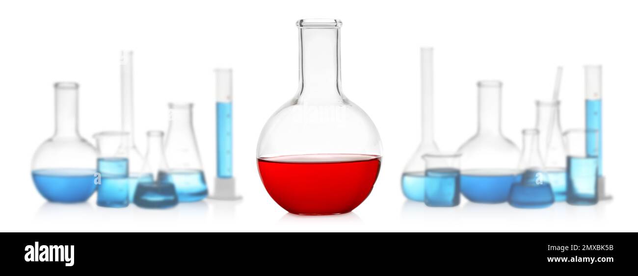 Florence flask with red liquid near laboratory glassware on white