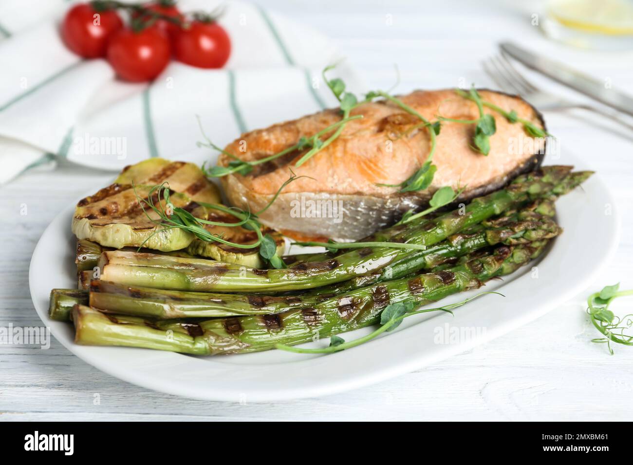 Tasty salmon steak served with grilled asparagus on plate Stock Photo