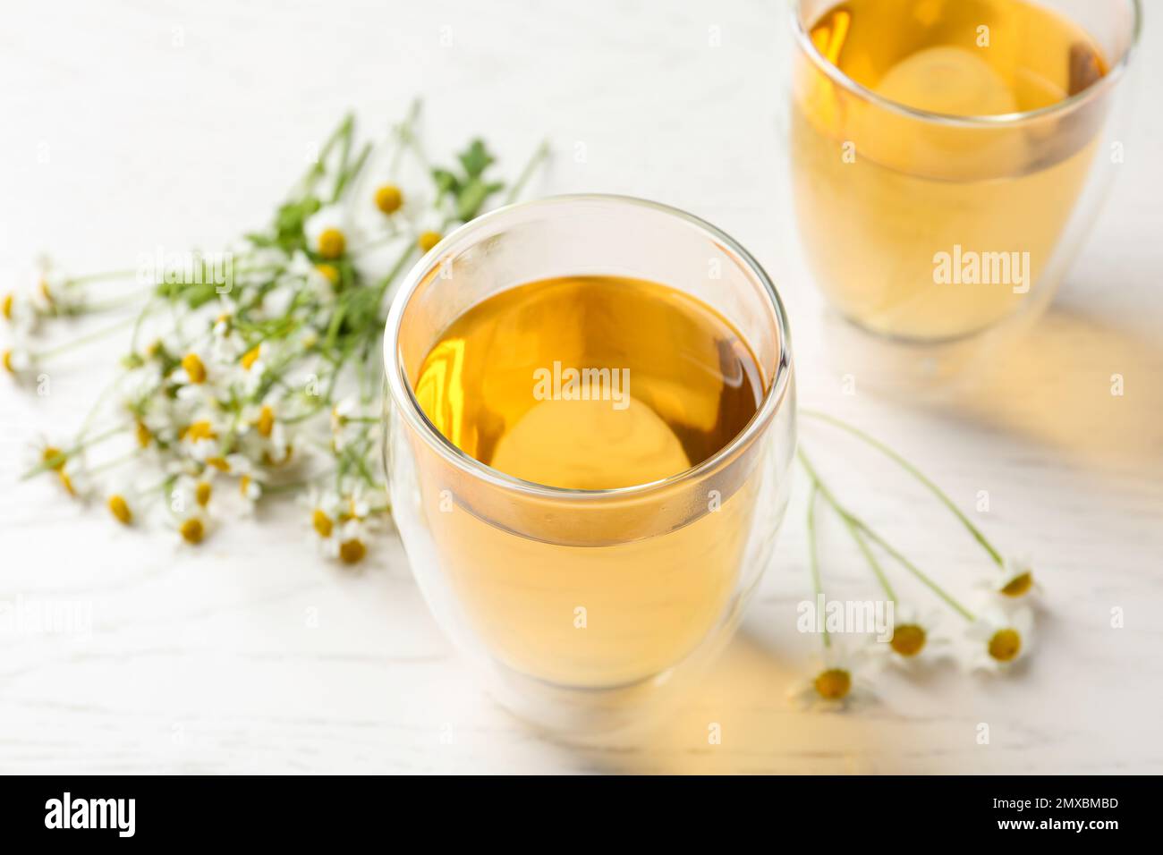 Delicious chamomile tea in glass on white table Stock Photo - Alamy