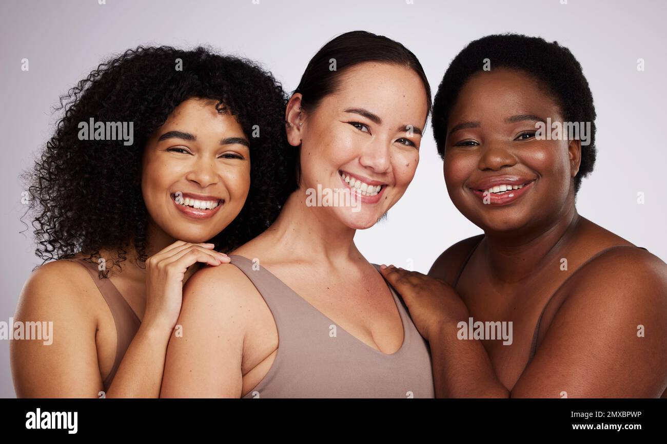 Portrait, diversity and women with skincare, smile and bonding together on grey studio background. Face, multiracial and females with cosmetics Stock Photo