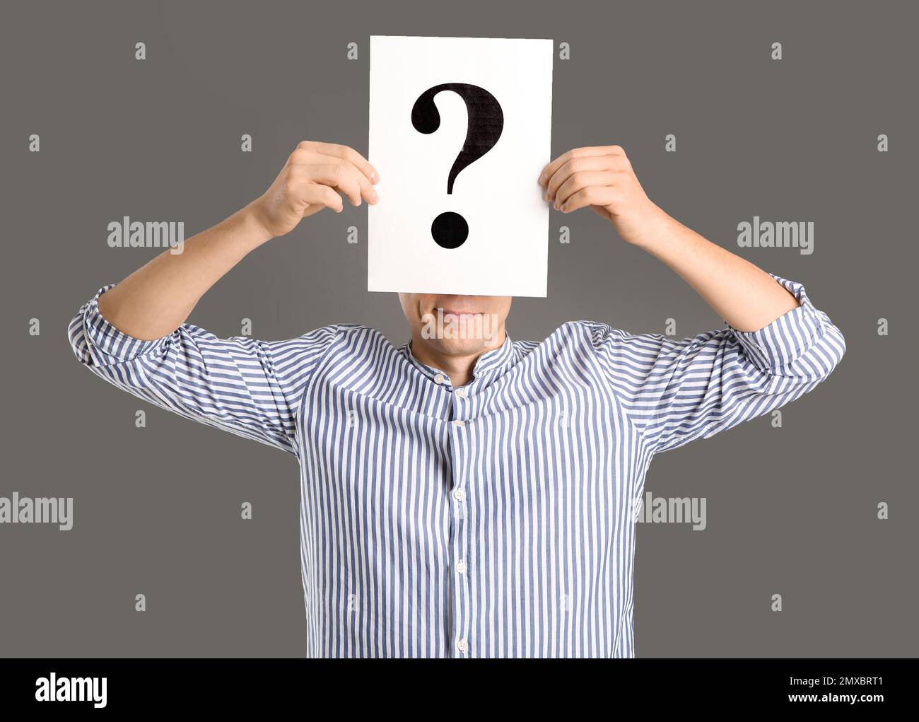 Man holding paper with question mark on grey background Stock Photo - Alamy