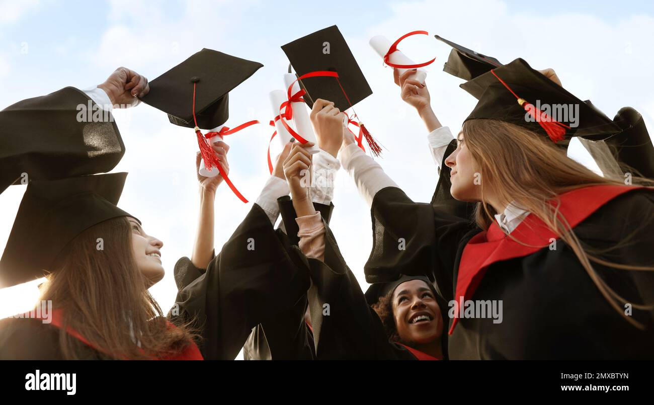 Group of students with diplomas outdoors. Banner design Stock Photo