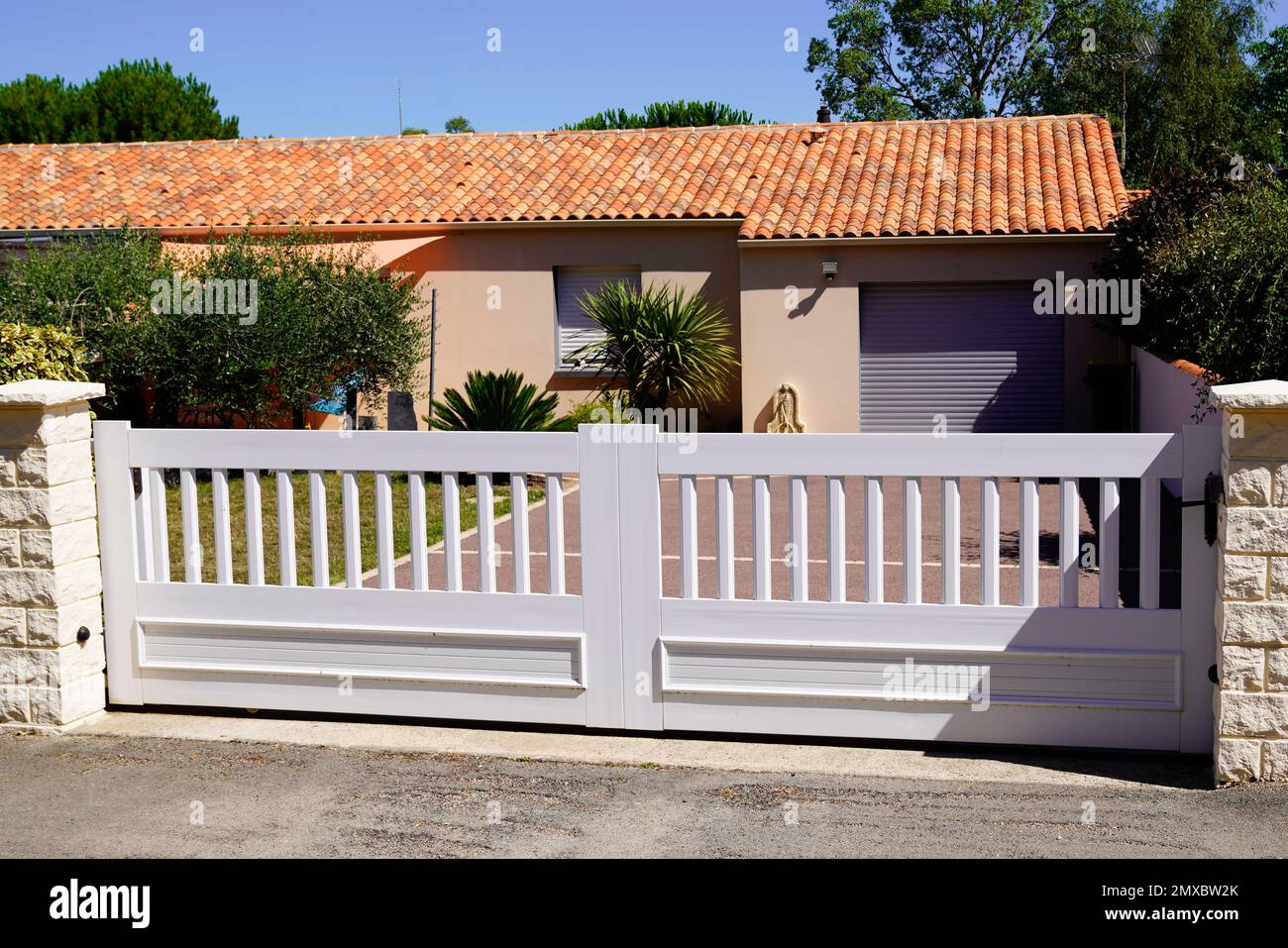 white low door aluminum gate sliding slats portal garden entry suburb house Stock Photo