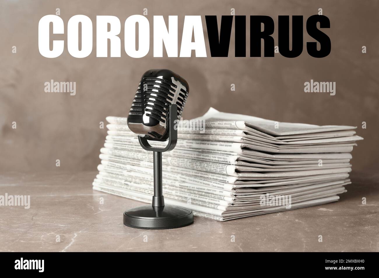 Word CORONAVIRUS, newspapers and vintage microphone on marble table. Journalist's work Stock Photo