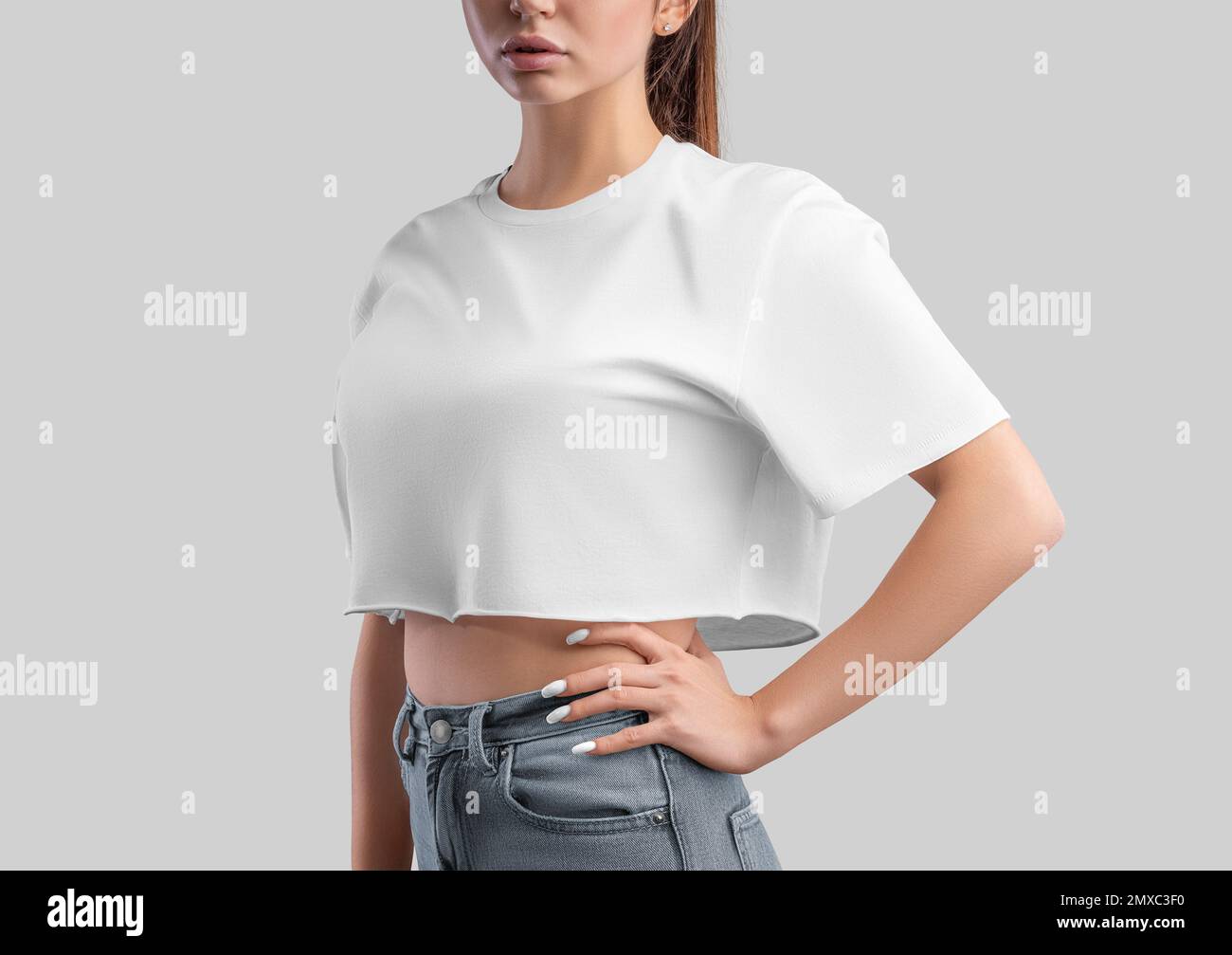 White t-shirt template, crop top on a girl in jeans, isolated on  background, side view. Free cut t-shirt mockup, empty clothes oversized.  Fashion shir Stock Photo - Alamy