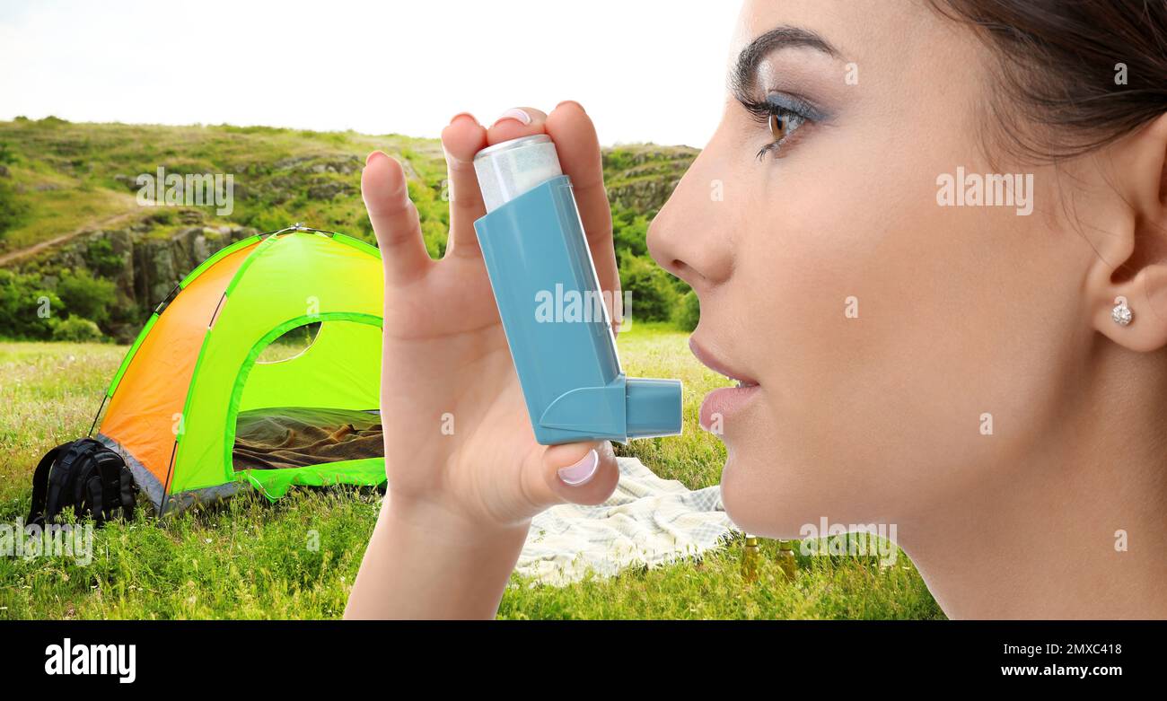 Young woman using asthma inhaler outside on sunny day. Emergency first aid during outdoor recreation Stock Photo