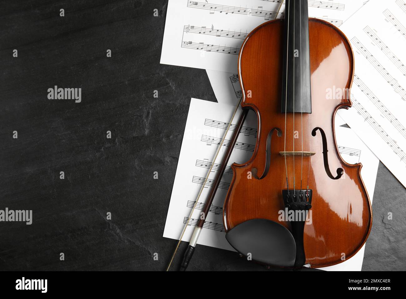 Violin, bow and note sheets on wooden table, flat lay. Space for text Stock Photo