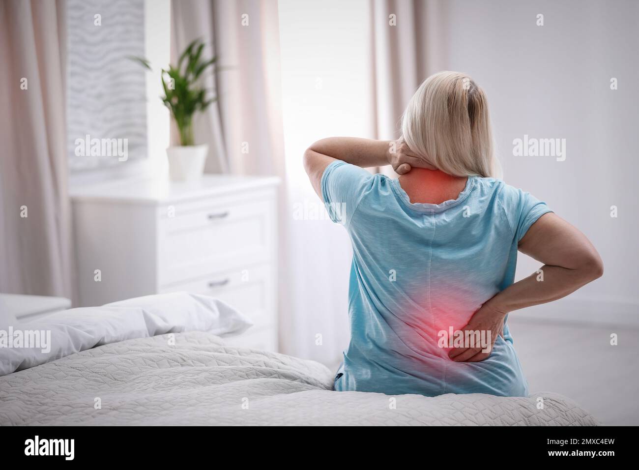 Senior woman suffering from pain in back at home Stock Photo - Alamy