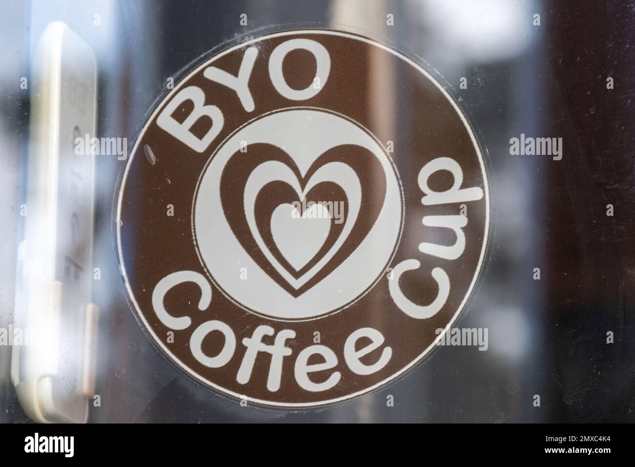 BYO coffee cup, Bring your own coffee cup sticker in cafe window, aiming to reduce usage of single use plastics, UK Stock Photo