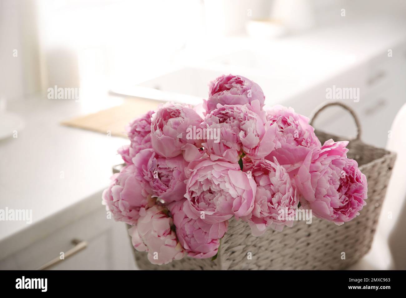 Basket with beautiful pink peonies in kitchen Stock Photo - Alamy