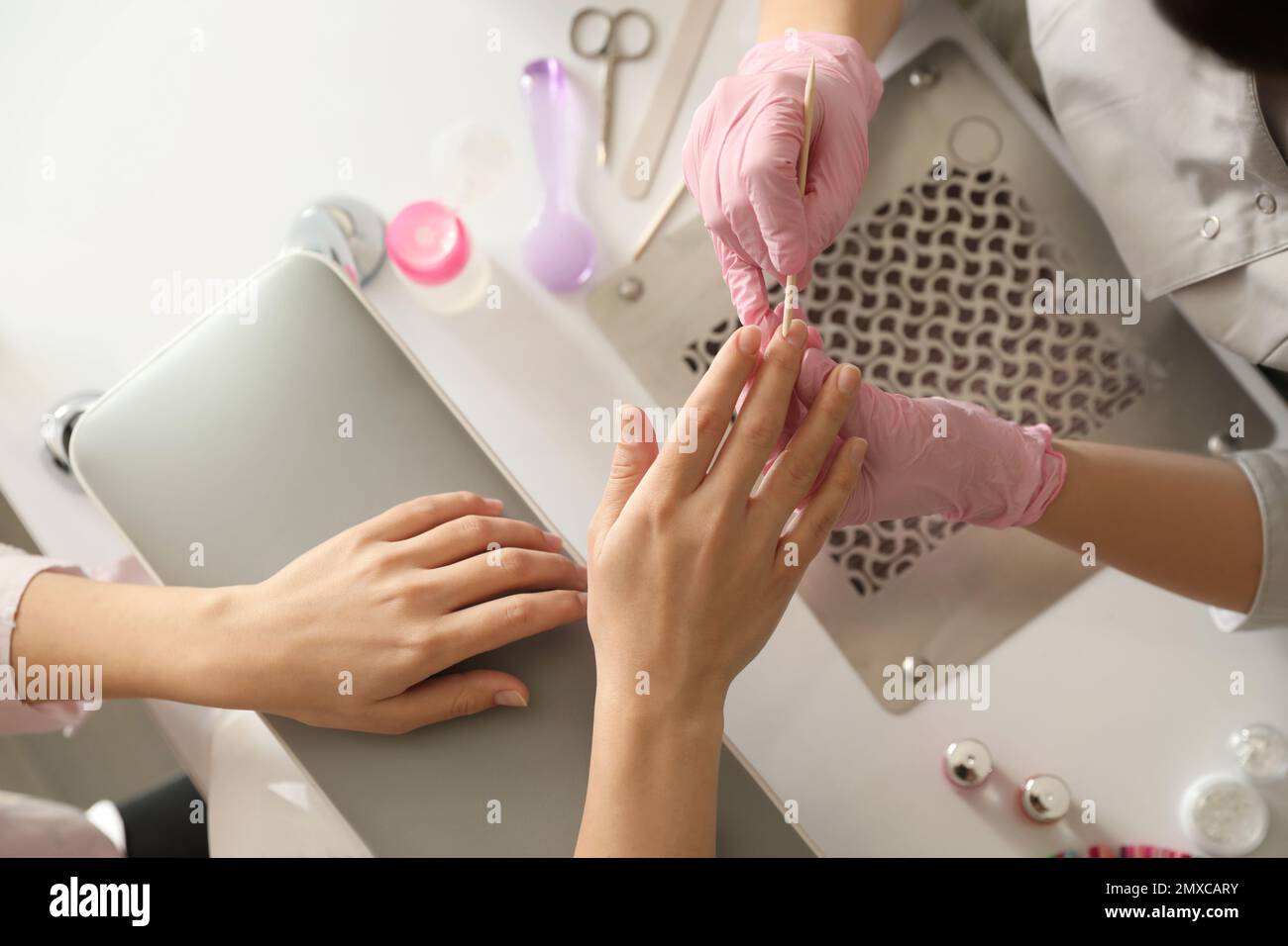 Professional manicurist working with client in beauty salon, top view ...