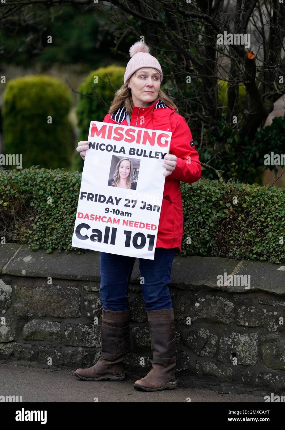 A member of the public lines the road into St Michael's on Wyre, Lancashire, with missing posters of Nicola Bulley, 45, as police continue their search for the missing woman who was last seen on the morning of Friday January 27, when she was spotted walking her dog on a footpath by the nearby River Wyre. Picture date: Friday February 3, 2023. Stock Photo