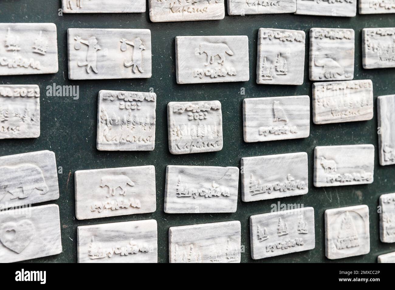 Ruskeala, Russia - June 12, 2021: White marble magnets with decorative carvings. Text means Ruskeala town name in Russian Stock Photo