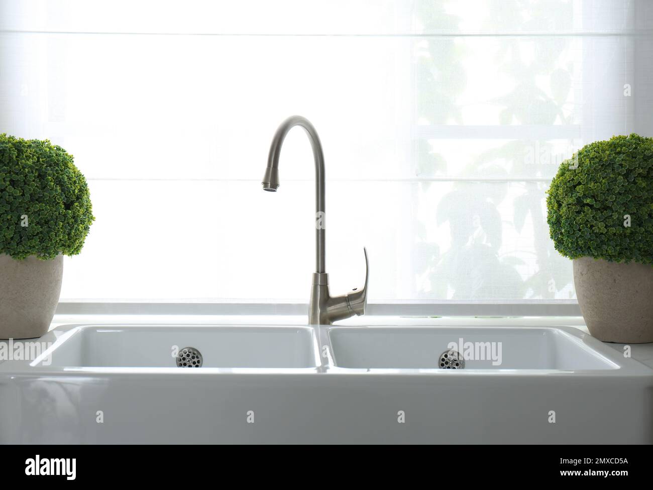 Modern double bowl sink near window in kitchen Stock Photo - Alamy