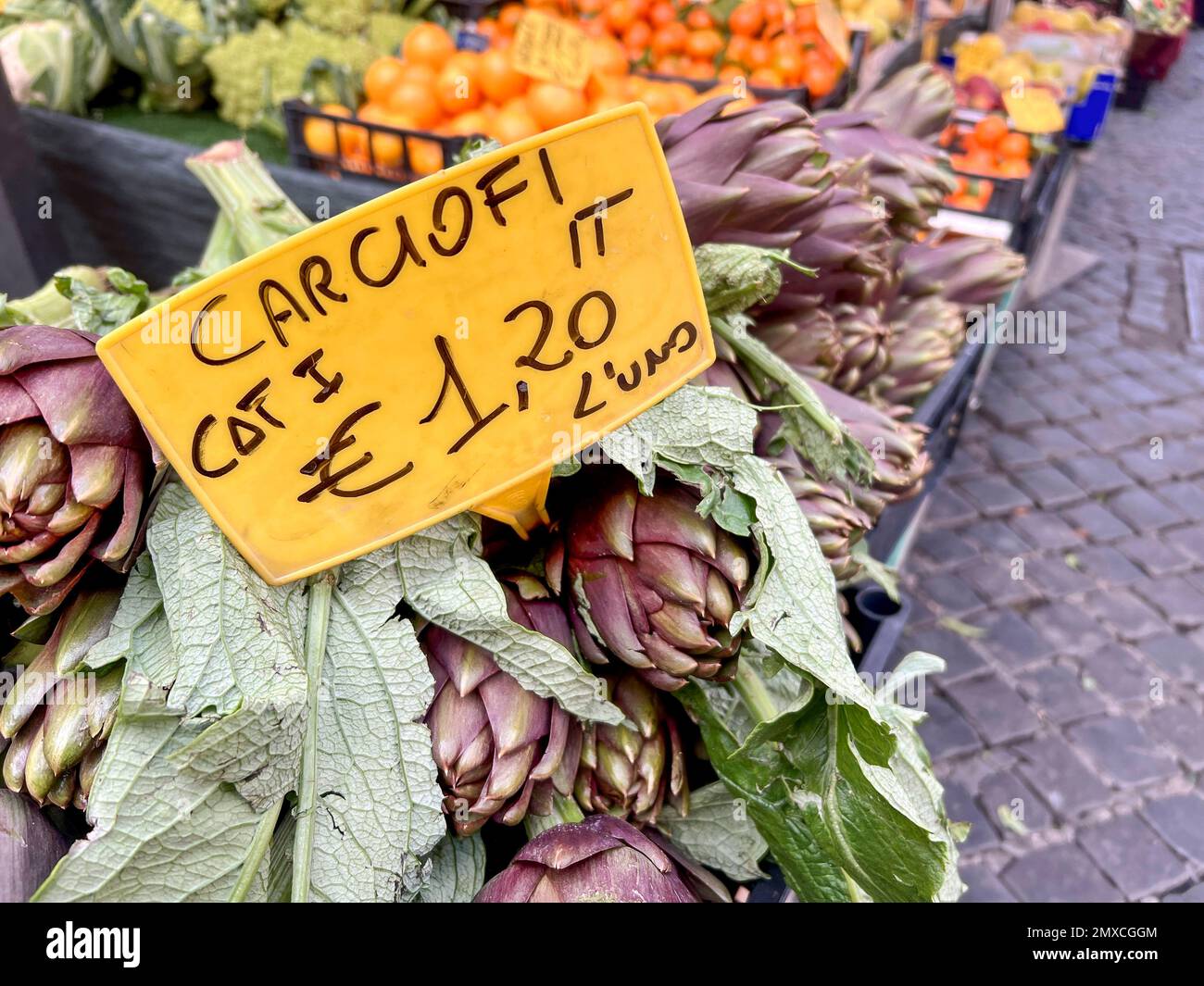 market, italian price tag on fresh artichokes with selective focus in an open farmers market in Italy. fresh and ripe artichoke on vegetable stands or Stock Photo