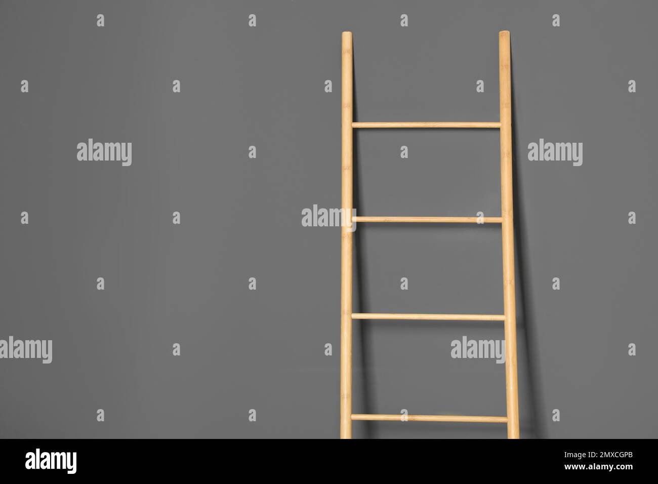 Modern wooden ladder on grey background. Space for text Stock Photo - Alamy