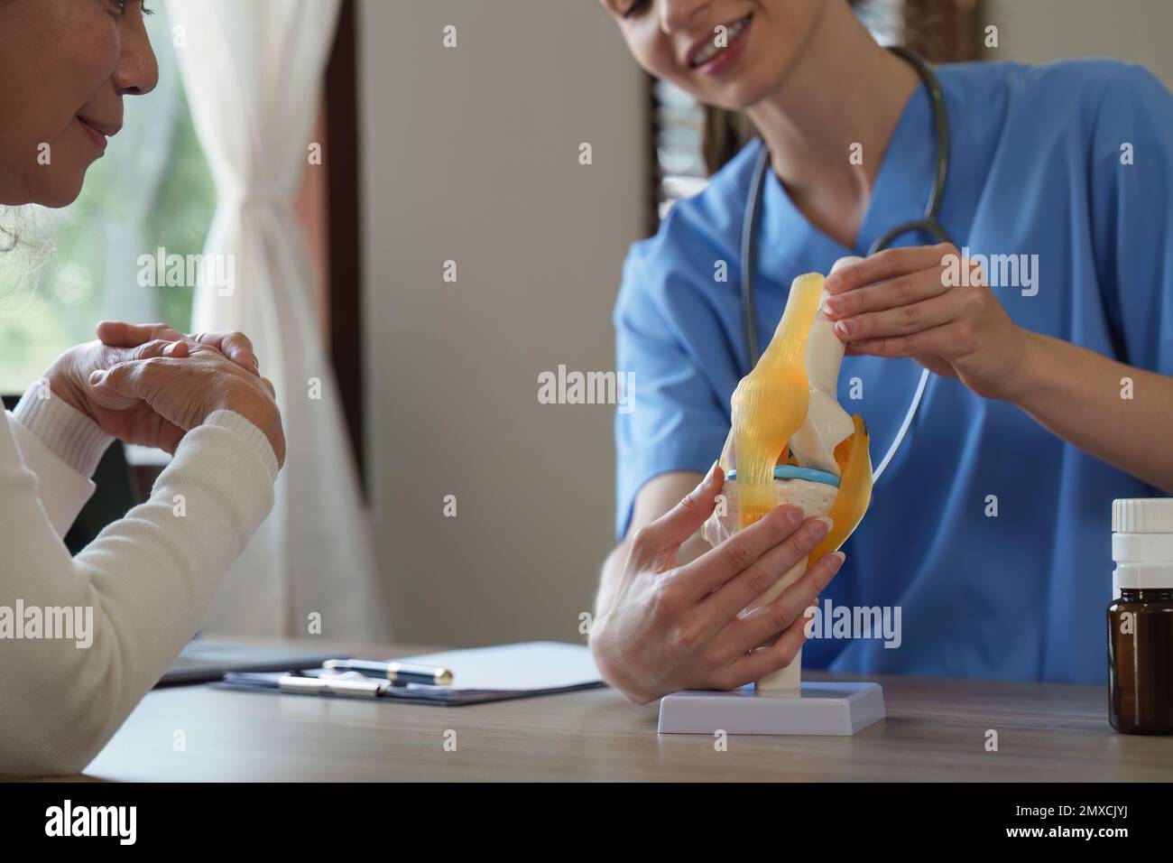 Professional Doctor explain on area of model knee joint at clinic ...