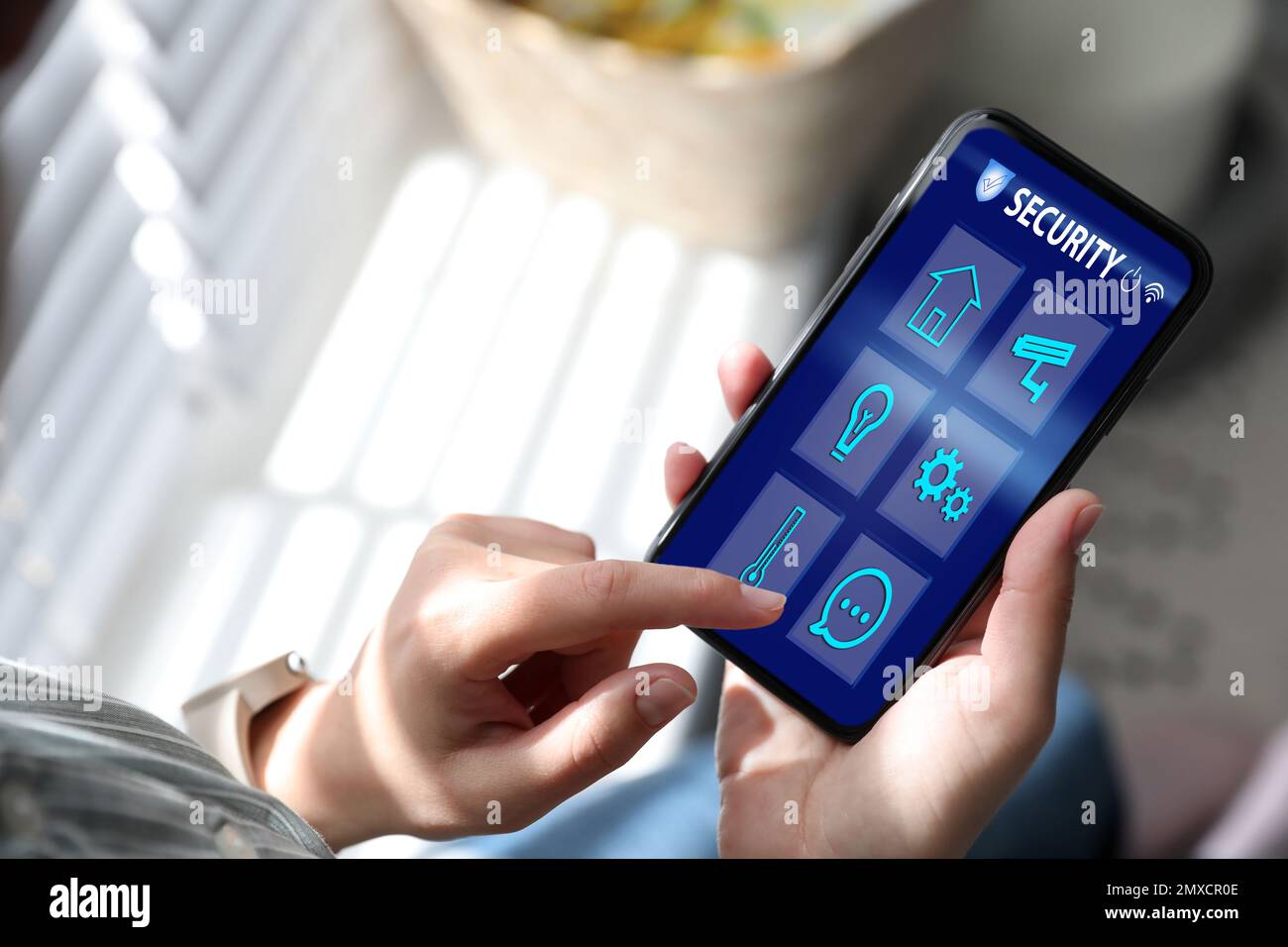 Woman monitoring modern CCTV cameras on smartphone indoors, closeup ...