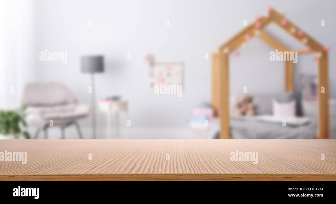 Empty wooden table in baby room interior Stock Photo - Alamy