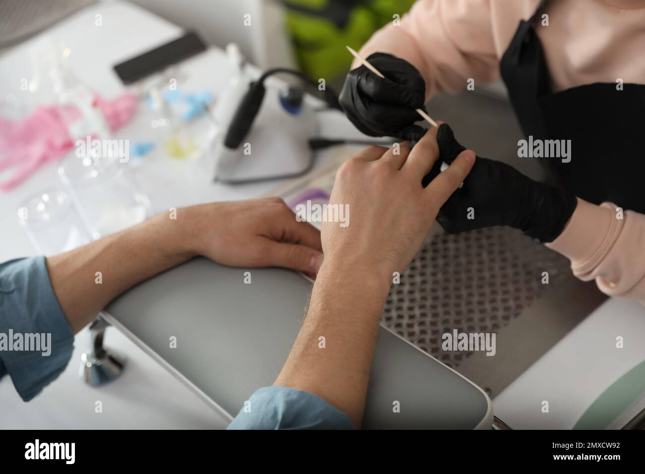 Professional manicurist working with client in beauty salon, closeup ...