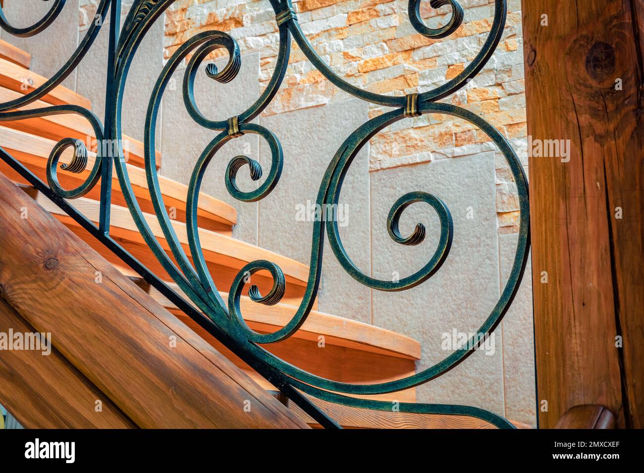 Elements of wrought iron railings and wooden stairs in a mountain chalet in the Carpathians. Stock Photo