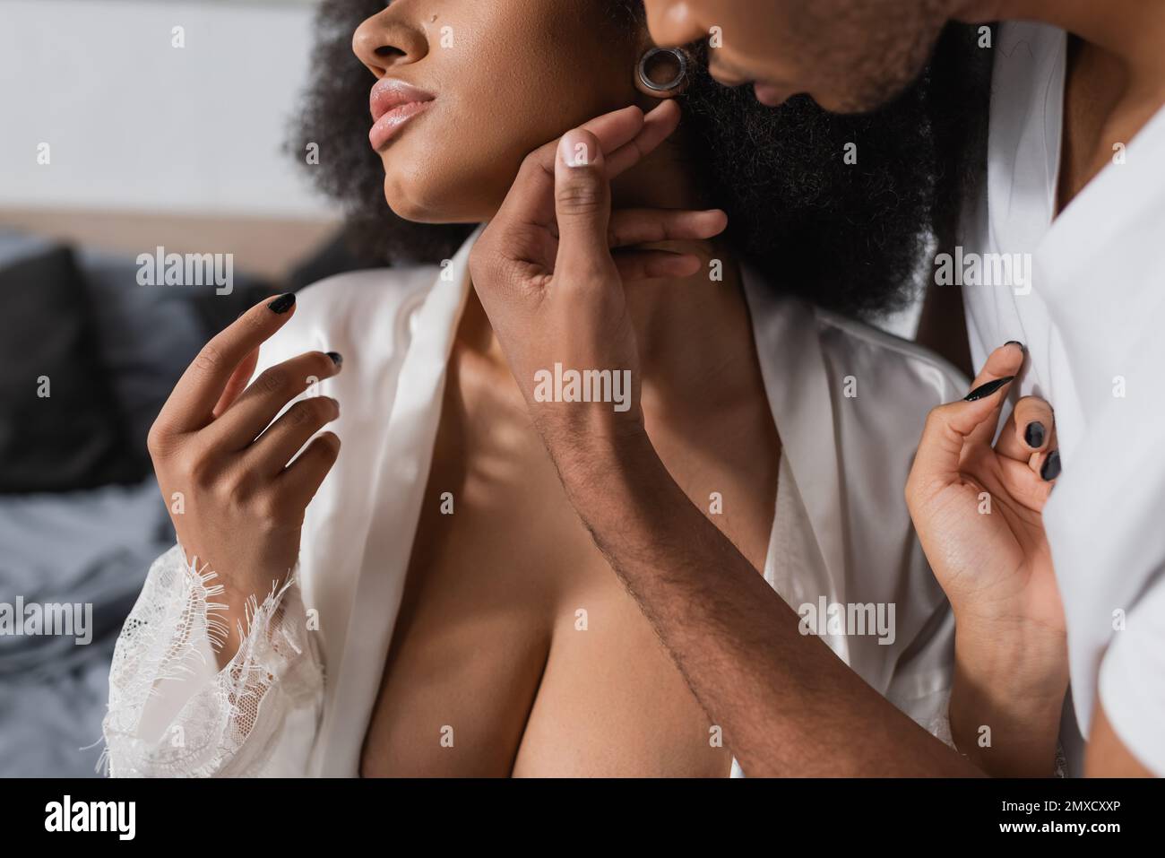 cropped view of african american man touching passionate girlfriend with sexy bust in bedroom Stock Photo