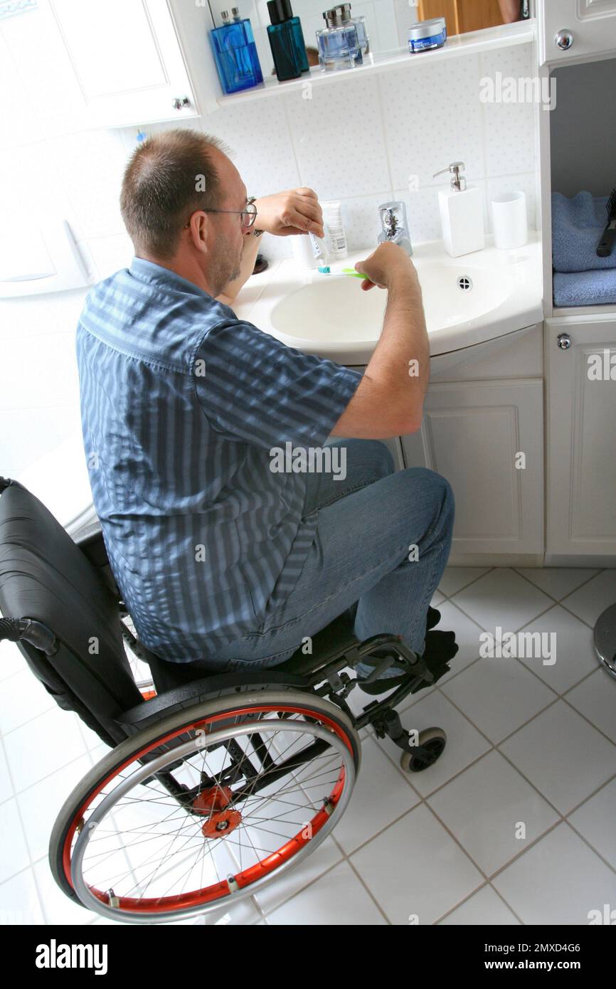 wheelchair user brushing his teeth in the bathroom Stock Photo Alamy