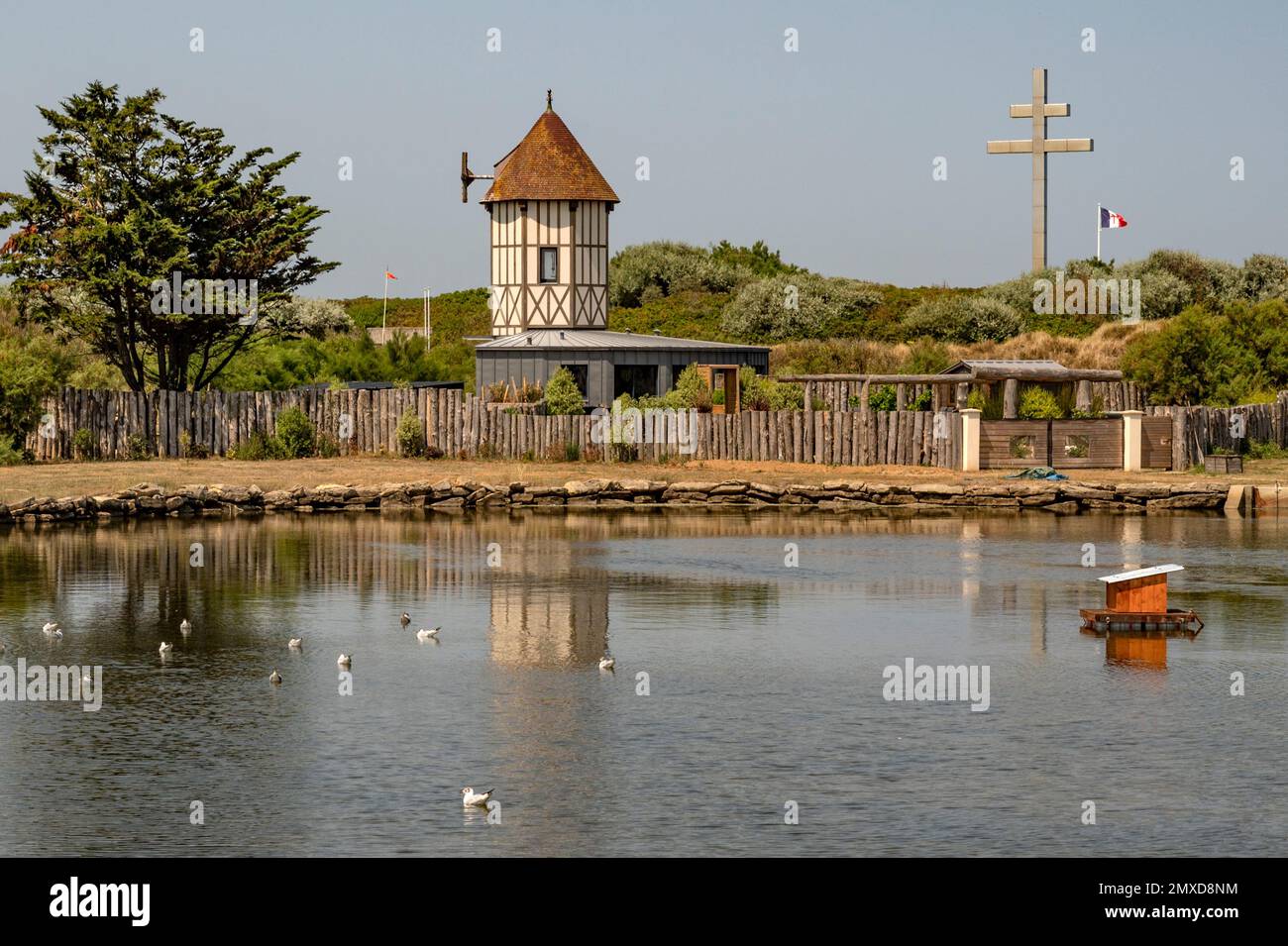 Peaceful lake and cross of war (croix de lorraine) at Courseulles-sur-Mer at Normandy's landing beaches, France Stock Photo