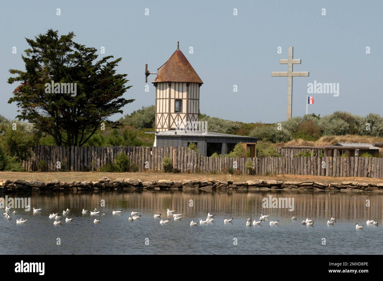 Peaceful lake and cross of war (croix de lorraine) at Courseulles-sur-Mer at Normandy's landing beaches, France Stock Photo