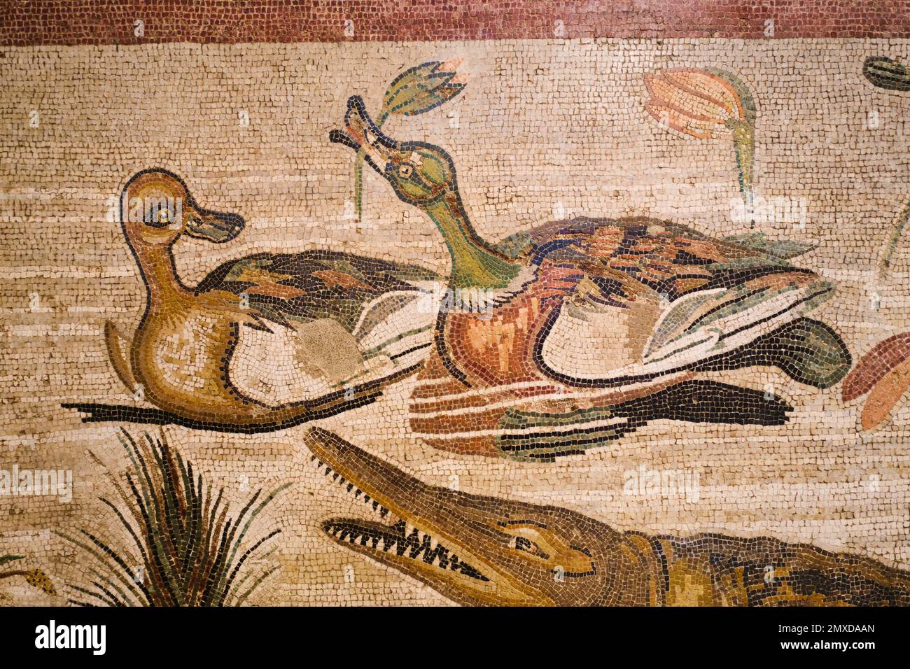 Artwork of a couple of ducks, eating a flower with an alligator, crocodile. An old tile mosaic at the Archeological Museum, Museo Archeologico Naziona Stock Photo