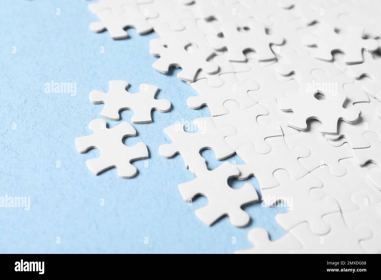 Blank white puzzle pieces on light blue background Stock Photo
