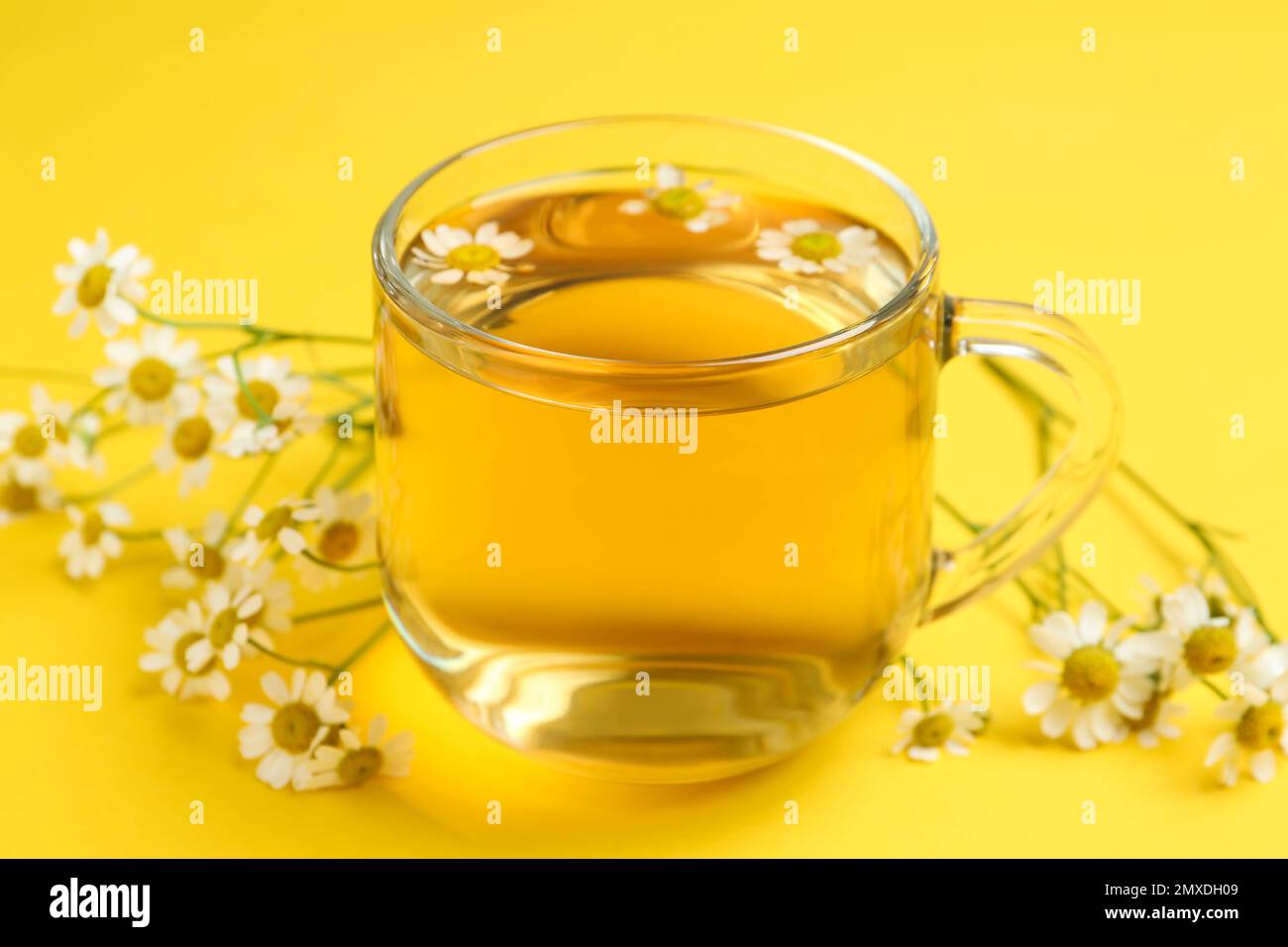 Cup of tea and chamomile flowers on yellow background Stock Photo - Alamy