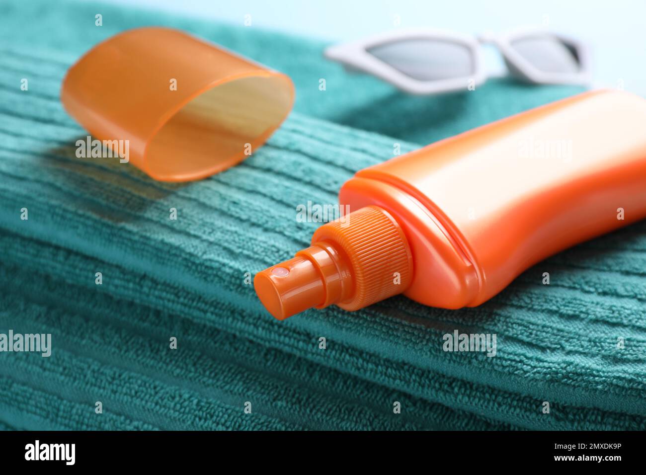 Sun protection spray on towel, closeup view Stock Photo Alamy