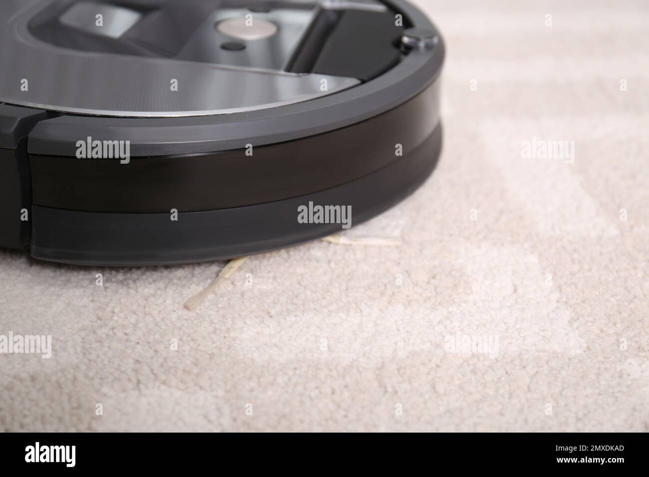 Hoovering floor with modern robotic vacuum cleaner indoors, closeup