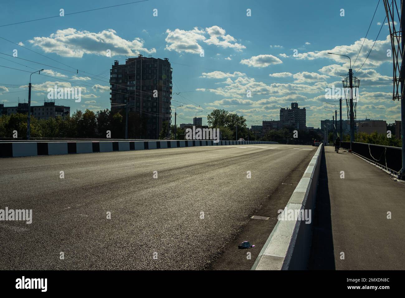 Empty city road against the background of houses and a cloudy summer sky. Photo taken in Chelyabinsk Russia. Stock Photo