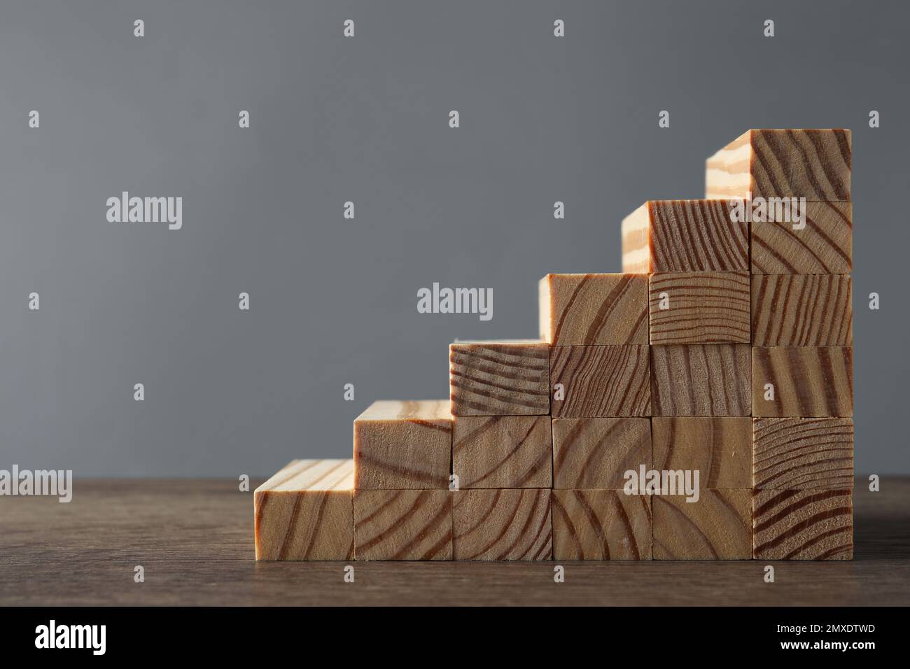 Steps made with wooden blocks on table against grey background, space ...