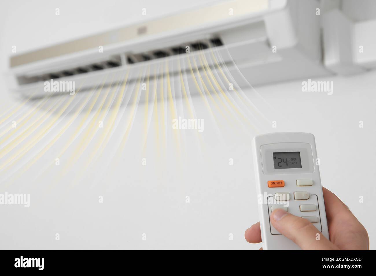 Man operating air conditioner with remote control indoors, closeup ...