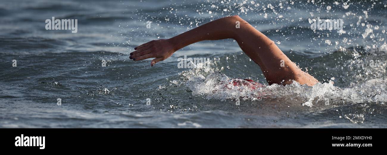 Arm of a swimmer athlete swimming in the ocean, competition swimming at
