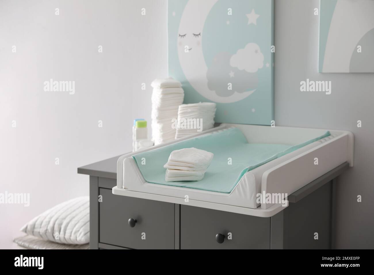 Chest of drawers with changing tray and pad in baby room. Interior