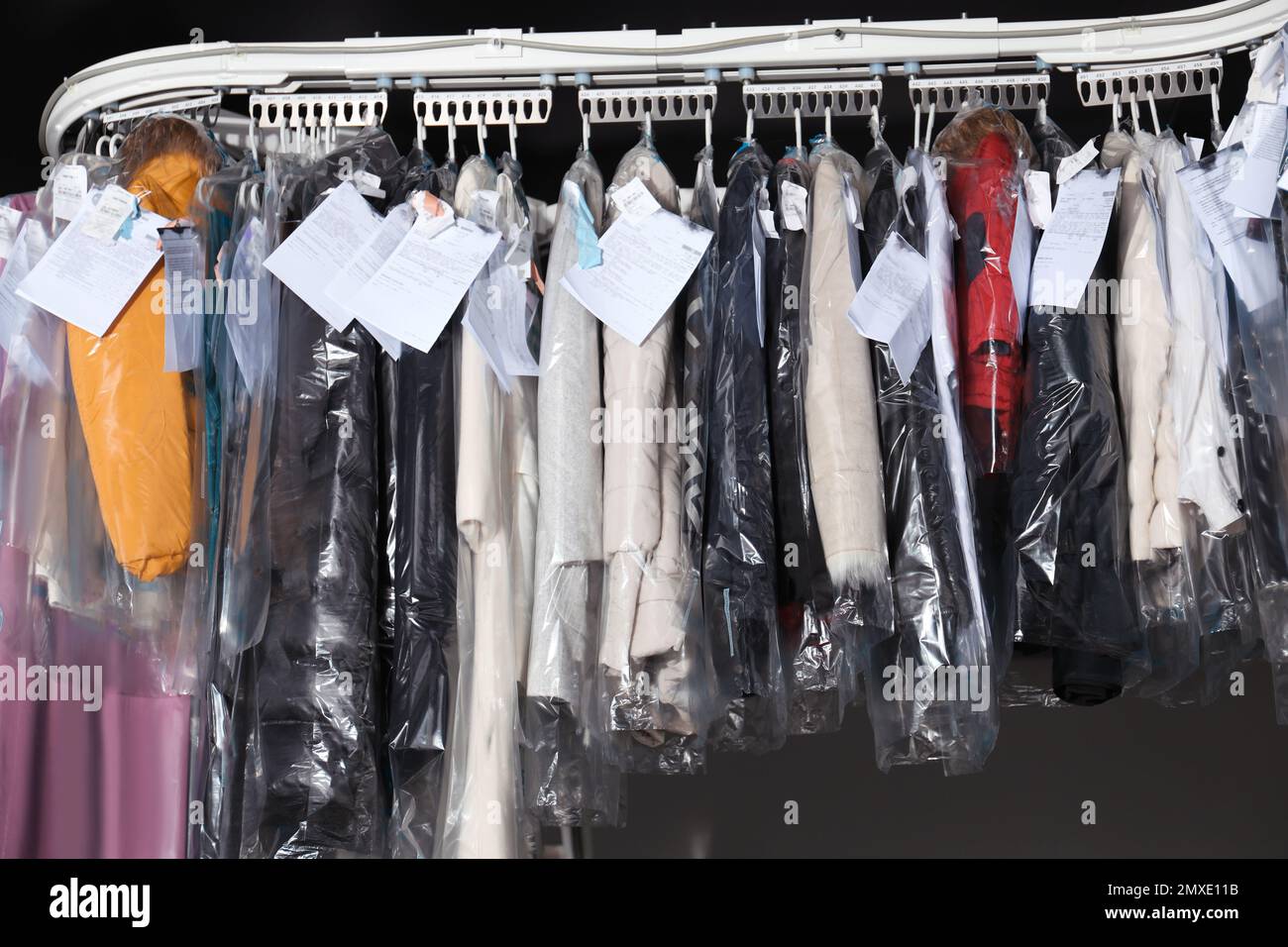 Hangers with clothes on garment conveyor at drycleaner's Stock Photo
