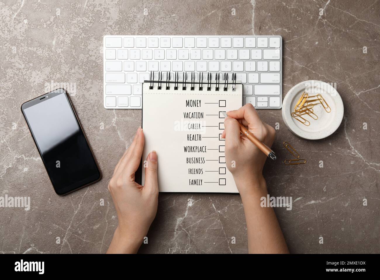 Work-life balance concept. Woman writing in notebook at grey marble ...