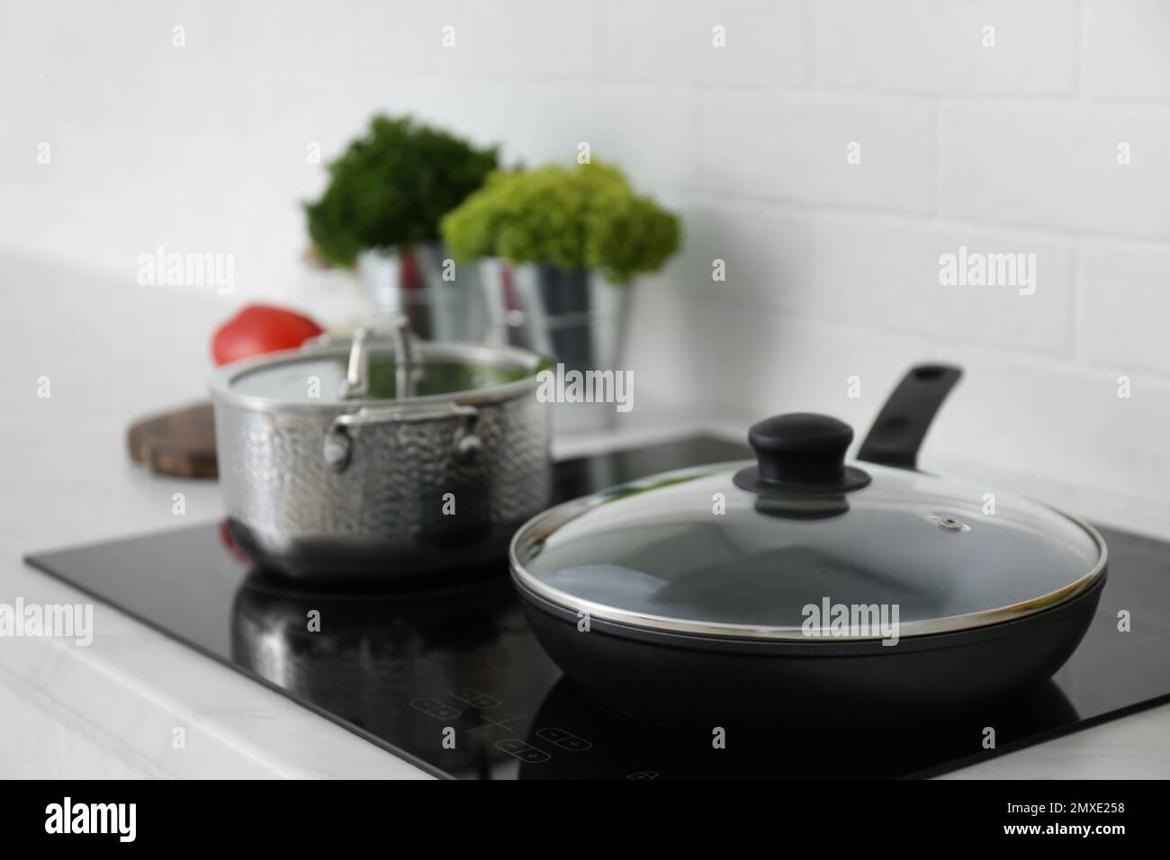 Saucepot and frying pan on induction stove in kitchen Stock Photo Alamy