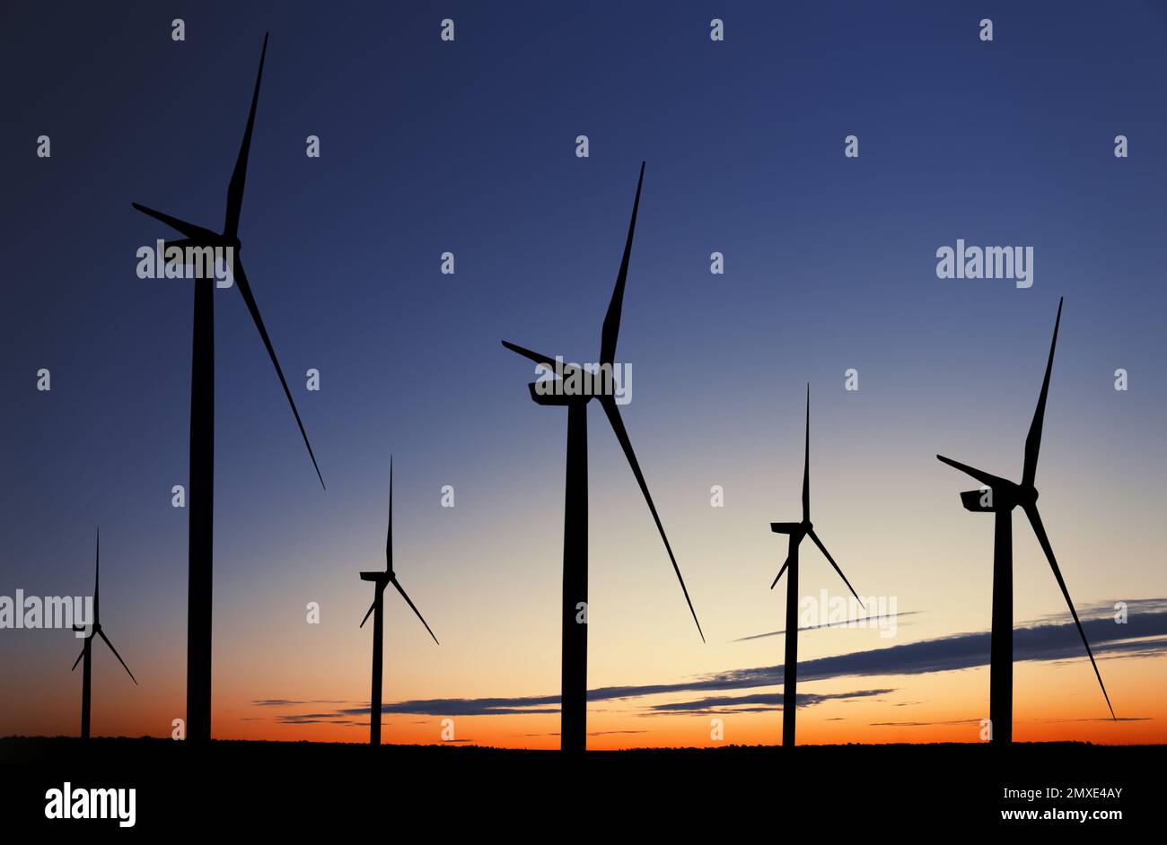 Silhouettes of wind turbines at sunset. Alternative energy source Stock ...